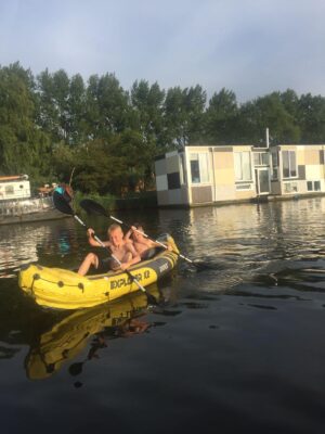 Roeien in ons bootje bij de woonboten